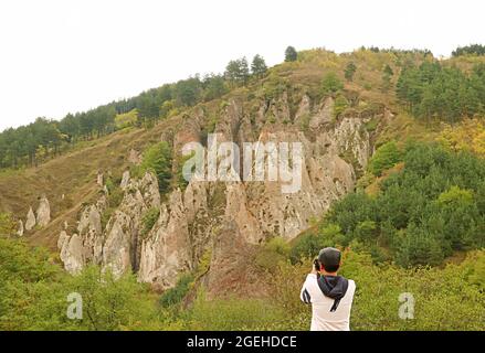 Reisende, die Fotos von fantastischen Felsformationen im Dorf der alten Khndzoresk-Höhle in der Provinz Syunik, Armenien, machen Stockfoto