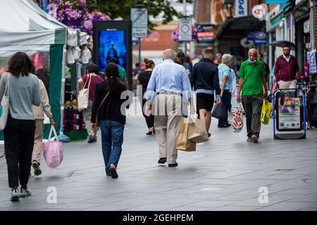 London, Großbritannien. 20. August 2021. Menschen, die im Stadtzentrum von Harrow-on-the-Hill, im Nordwesten Londons, einkaufen. Das Office for National Statistics (ONS) hat bekannt gegeben, dass die Einzelhandelsumsätze in Großbritannien im Juli auf den niedrigsten Stand seit der Wiedereröffnung der Geschäfte im April gesunken sind, wobei Einzelhändler berichten, dass das Fußballturnier der Euro 2020 und das schlechte Wetter die Käufer von den Geschäften fernhielten. Kredit: Stephen Chung / Alamy Live Nachrichten Stockfoto