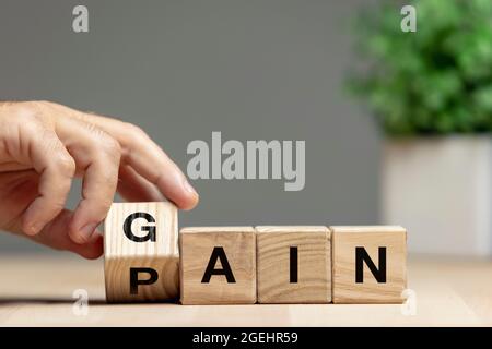 Weibliche Hand drehen Holzwürfel, Block und ändern Sinn des Wortes GEWINNEN. Konzeptionelles Bild über Menschenrechte, Bildung, soziale Fragen, psychische Gesundheit Stockfoto