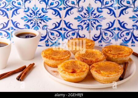 Eiertarte, traditionelles portugiesisches Dessert, Pastell de nata/Pastell de belem. Hintergrund der Azulejo-Kachel. Stockfoto