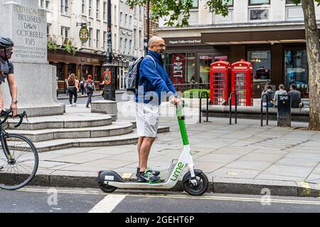 LONDON, GROSSBRITANNIEN. 20. August 2021. Ein Mann, der einen gemieteten Lime Elektroroller in London fährt. Am Montag, dem 7. Juni, wurde ein Test-E-Scooter-Mietprogramm gestartet, das zunächst 12 Monate in bestimmten Londoner Stadtteilen lief. Die Polizei hat mit der Beschlagnahme von privaten E-Scootern, die im Vereinigten Königreich illegal sind, begonnen, außer wenn sie auf privatem Land verwendet werden. Credit amer Ghazzal/Alamy Live News Stockfoto