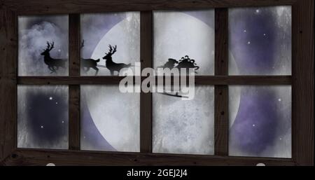 Bild der Silhouette des weihnachtsmannes im Schlitten, der von Rentieren und der winterweihnachtszene gezogen wird Stockfoto