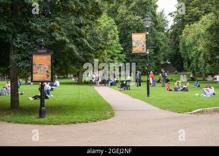 Menschen, die sich entspannen und einen warmen, sonnigen Tag auf dem Gelände der Kathedrale, Winchester, Hampshire, England, Großbritannien, genießen Stockfoto