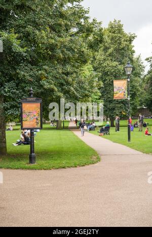 Menschen, die sich entspannen und einen warmen, sonnigen Tag auf dem Gelände der Kathedrale, Winchester, Hampshire, England, Großbritannien, genießen Stockfoto