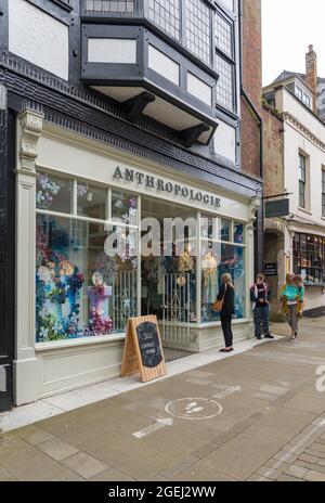 Frau, die in Anthropologie, einem Geschäft, das boho-schicke Damenmode, Schuhe, Accessoires und Einrichtungsgegenstände verkauft, Schaufensterauslagen ansieht. High Street, Winchester. Stockfoto