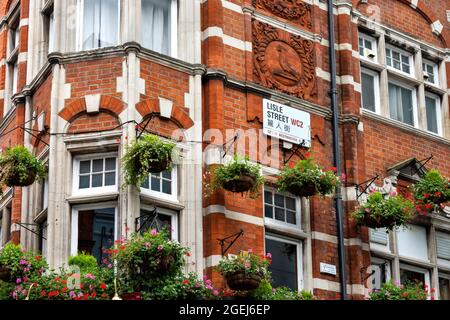 LONDON LISLE STREET CHINATOWN GEBÄUDE MIT HÄNGENDEN BLUMENKÖRBEN UND STRASSENSCHILD AUF CHINESISCH Stockfoto