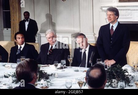 Der Präsident der Vereinigten Staaten, Jimmy Carter, rechts, hält am Montag, den 7. März 1977, bei einem Arbeitsessen zu Ehren des israelischen Ministerpräsidenten Yitzhak Rabin, rechts in der Mitte, im Staatlichen Speisesaal des Weißen Hauses in Washington, DC, eine Rede. Ein Blick darauf ist der Sprecher des US-Repräsentantenhauses, Tip O’Neill (Demokrat von Massachusetts), links in der Mitte, und der US-Botschafter bei den Vereinten Nationen, Andrew Young.Quelle: Benjamin E. 'Gene' Forte / CNP /MediaPunch Stockfoto