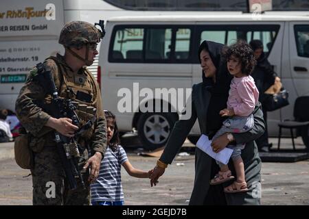 Kabul, Afghanistan. August 2021. Eine Marine, die der 24. Marine Expeditionary Unit zugewiesen ist, begleitet Evakuierte am Hamid Karzai International Airport, Afghanistan, 20. August 2021. US-Dienstmitglieder unterstützen das Außenministerium bei einer nicht-kämpferischen Evakuierungsoperation (NEO) in Afghanistan. Foto von CPL. Davis Harris/USMC/UPI Credit: UPI/Alamy Live News Stockfoto