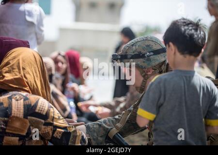 Kabul, Afghanistan. August 2021. Ein Corpsman mit der 24. Marine Expeditionary Unit (MEU) überprüft das Wohlergehen der Evakuierten während einer Evakuierung am Hamid Karzai International Airport in Kabul, Afghanistan, am 20. August 2021. US-Dienstmitglieder unterstützen das Außenministerium bei einer geordneten Abseichung von designiertem Personal in Afghanistan. Foto von Sgt. Samuel Ruiz/USMC/UPI Kredit: UPI/Alamy Live Nachrichten Stockfoto