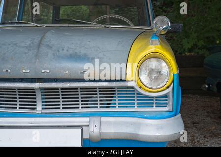 KÖLN, DEUTSCHLAND - 25. Jul 2021: Ein Vorderteil eines Vintage-Ford Taunus in Gelb und Blau, hergestellt in den 60er Jahren Stockfoto