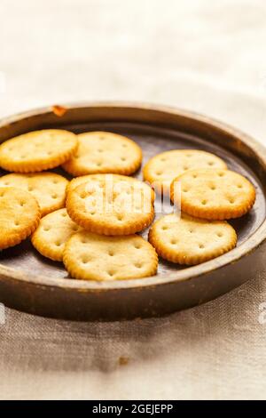 Käsekekse oder Cracker auf einem Holzteller Stockfoto