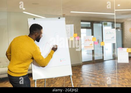 Serious afroamerikanischen männlichen Unternehmen kreativ mit Whiteboard, die Präsentation Stockfoto