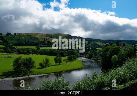 Dee River Valley, Wales. Schöne Landschaftsansicht auf idyllische Landschaft. Grüne Felder und Hügel mit dem anmutigen Fluss fließt. Walisische ländliche Szene. Stockfoto