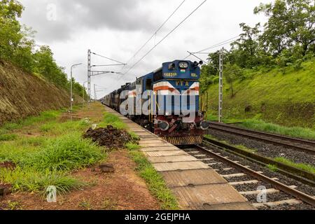 02413 Madgaon - Neu Delhi Rajdhani Special wartet auf die Überfahrt am Bahnhof der Vaibhavwadi Road auf der Konkan Railway in Maharashtra, Indien. Stockfoto