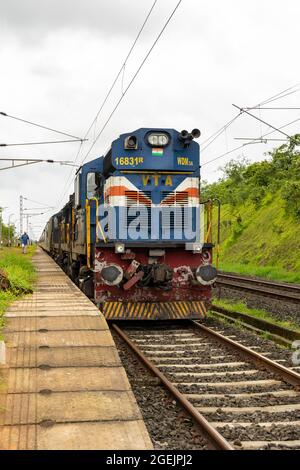 02413 Madgaon - Neu Delhi Rajdhani Special wartet auf die Überfahrt am Bahnhof der Vaibhavwadi Road auf der Konkan Railway in Maharashtra, Indien. Stockfoto