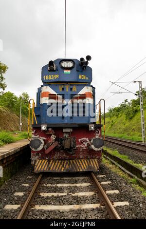 Vorderansicht der Lokomotive der indischen Eisenbahn der Baureihe WDM-3A aus dem Vatva-Schuppen. Elektrokabel über dem Motor, was auf die Elektrifizierung der Konkan-Eisenbahn hinweist Stockfoto