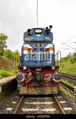 Vorderansicht der Lokomotive der indischen Eisenbahn der Baureihe WDM-3A aus dem Vatva-Schuppen. Elektrokabel über dem Motor, was auf die Elektrifizierung der Konkan-Eisenbahn hinweist Stockfoto
