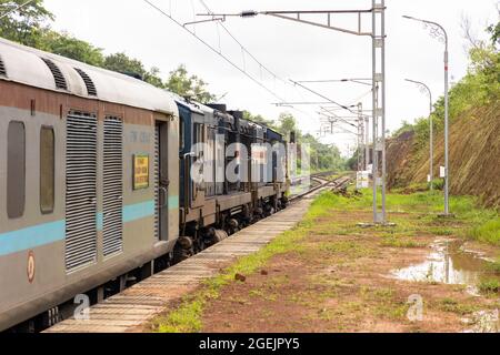 02413 Madgaon - Neu Delhi Rajdhani Special wartet auf die Überfahrt am Bahnhof der Vaibhavwadi Road auf der Konkan Railway in Maharashtra, Indien. Stockfoto