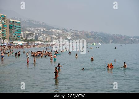 Menschen baden im Meer in Fuengirola an einem sehr heißen Tag mit Calima (Staubschicht aus der Sahara). Malaga, Spanien Stockfoto