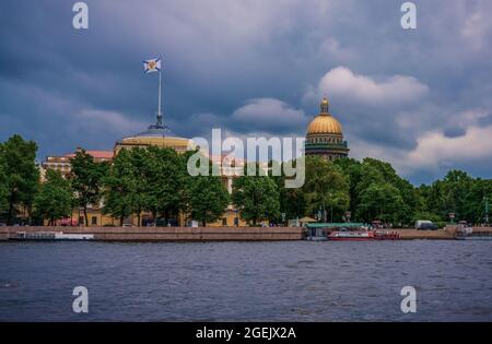 Blick vom Fluss Neva auf das Admiralität-Gebäude und die Isaakskathedrale vor stürmischem Himmel. Stockfoto