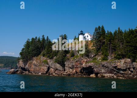 Der Leuchtturm von Bear Island liegt auf felsigen Klippen inmitten immergrüner Bäume im Acadia National Park in Maine. Bootstouren bieten eine großartige Aussicht auf das Licht Stockfoto