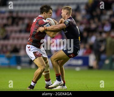 Wigan, Großbritannien. August 2021. Liam Byrne (19) von Wigan Warriors und Matty Lees (10) von St Helens treten am 8/20/2021 in Wigan, Großbritannien, um den Ball an. (Foto von Simon Whitehead/ SW Foto/News Images/Sipa USA) Quelle: SIPA USA/Alamy Live News Stockfoto