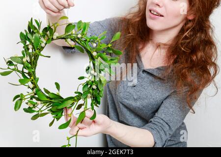 Florist bei der Arbeit: Wie man Misteltürkranz macht, Schritt für Schritt, Tutorial. Stockfoto