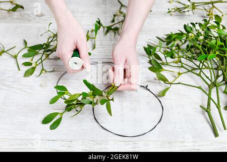 Florist bei der Arbeit: Wie man Misteltürkranz macht, Schritt für Schritt, Tutorial. Stockfoto