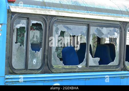 Heruntergekommener und rostiger Bus mit kaputten Fenstern in einer abgelegenen Gegend. Stockfoto