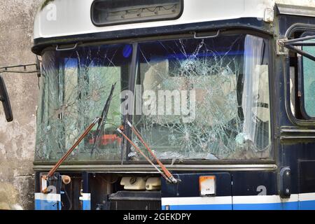 Heruntergekommener und rostiger Bus mit kaputten Fenstern in einer abgelegenen Gegend. Stockfoto