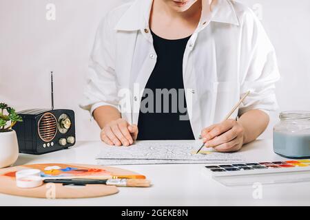 Kunsttherapie oder Selbstdarstellung für Erwachsene. Junge Frau Malseite Anti Stress Buch, geistiges Wohlbefinden und Kreativität Inspiration Ausdruck conce Stockfoto