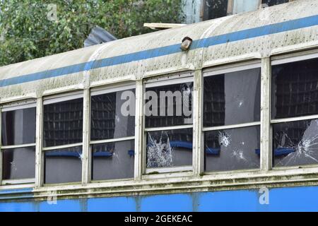 Heruntergekommener und rostiger Bus mit kaputten Fenstern in einer abgelegenen Gegend. Stockfoto