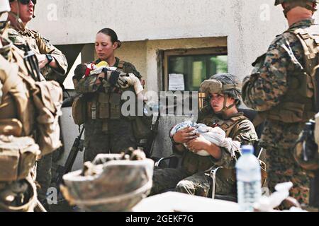 Kabul, Afghanistan. August 2021. US-Marineinfanteristen, die der 24. Marine Expeditionary Unit zugewiesen wurden, trösten und trösten Kleinkinder während der Evakuierung von nicht-Kombattanten am Hamid Karzai International Airport, Teil der Operation Allies Refuge am 20. August 2021 in Kabul, Afghanistan. Quelle: Planetpix/Alamy Live News Stockfoto