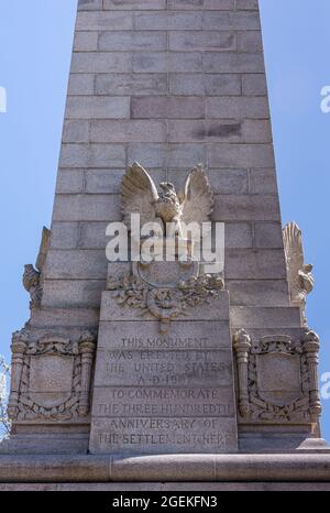 Jamestowne, VA, USA - 1. April 2013: Historische Stätte. Nahaufnahme der zweiten Seite des Tencentennial-Denkmals aus grauem Stein vor blauem Himmel. Statue von Adler A Stockfoto