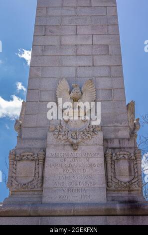 Jamestowne, VA, USA - 1. April 2013: Historische Stätte. Nahaufnahme der dritten Seite des Tencentennial-Denkmals aus grauem Stein vor blauem Himmel. Statue von Adler und Stockfoto