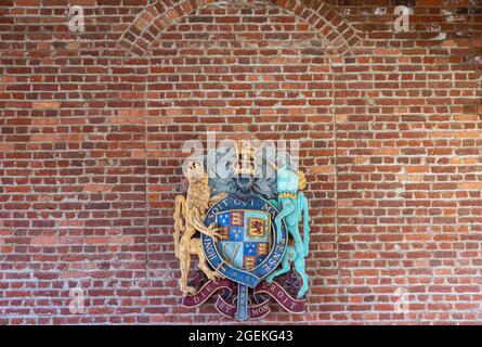 Jamestowne, VA, USA - 1. April 2013: Historische Stätte. Englisches königliches Wappen gegen rote Ziegelmauer. Motto ist Dieu et mon Droit. Stockfoto