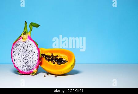 Zwei Hälften frische Bio-Drachenfrucht auf blauem Hintergrund, kreatives Sommer-Food-Konzept, Bannerhintergrund mit Kopierfläche, Minimalismus Trendy Food, Stockfoto