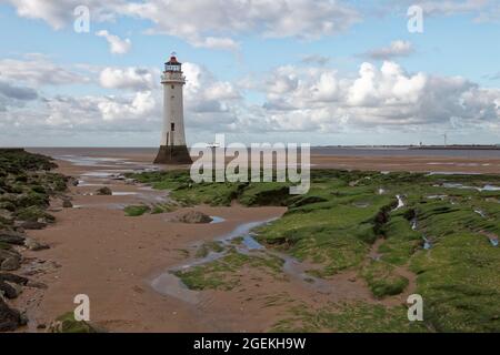 Der Leuchtturm von New Brighton bei Ebbe mit einem Frachtschiff der Irischen See Seatruck in der Ferne gesehen Stockfoto