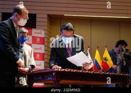 Bogota, Kolumbien. August 2021. Der Botschafter Südkoreas in Kolumbien, Jong Youn Choo (links) und der Gesundheitsminister Kolumbiens, Fernando Ruiz (rechts), unterzeichnen am 19. August 2021 die Spende von 4.5 Millionen Dollar durch Südkorea für die nachträgliche Genesung im Engativa Krankenhaus in Bogota, Kolumbien.Quelle: Long Visual Press/Alamy Live News Stockfoto