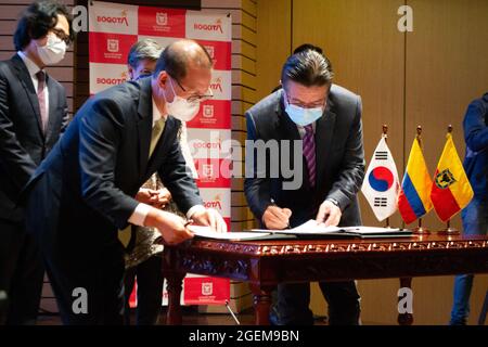 Bogota, Kolumbien. August 2021. Der Botschafter Südkoreas in Kolumbien, Jong Youn Choo (links) und der Gesundheitsminister Kolumbiens, Fernando Ruiz (rechts), unterzeichnen am 19. August 2021 die Spende von 4.5 Millionen Dollar durch Südkorea für die nachträgliche Genesung im Engativa Krankenhaus in Bogota, Kolumbien.Quelle: Long Visual Press/Alamy Live News Stockfoto