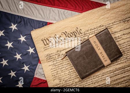 Eine heilige bibel und ein Kruzifix ruhen auf der Verfassung der Vereinigten Staaten und der amerikanischen Flagge, die für die Religionsfreiheit ohne Verfolgung steht. Stockfoto