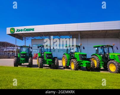 Kiew, Ukraine - 24. August 2020: Die leistungsstarken Traktoren im John Deer-Geschäft in Kiew, Ukraine, am 16. Juni 2020. Reihe brandneuer John Deere-Traktoren vor dem Laden des örtlichen Konsortiums, Ausstellung der neuesten landwirtschaftlichen Maschinen. Stockfoto