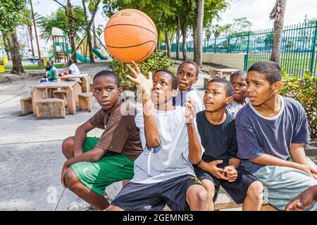 Miami Florida, Liberty City African Square Park Innenstadt, Schwarze Jungen männliche Kinder Kinder Gruppe Freunde Spielplatz, zeigt Basketball ausgleichende Spin Stockfoto