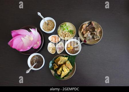 Miang Kham Bua Luang , traditionelle thailändische Snacks Lotusblüten Wraps mit Zuckersauce und Nüssen, Ingwer, getrocknete Garnelen, Kokosflocken Stockfoto