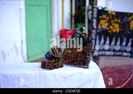 Pasuruan, Indonesien. Juni 2021. Verschiedene Arten von Werkzeugen, um handgemachte Batik und gestempelte Batik zu machen. Bemaltes Batik-Tuch und weißes Tuch bereit zum Stempel zu sein Stockfoto