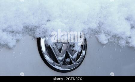 Nahaufnahme EINES schneebedeckten VW-Logos auf EINEM Auto Stockfoto