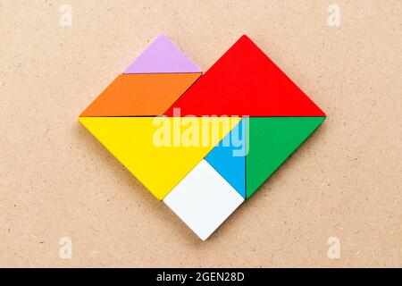 Farbe Tangram Puzzle in Herzform auf Holz Hintergrund Stockfoto