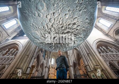 Der Resident Vicar, James Heard, steht mit der Installation des Museum of the Moon des Künstlers Luke Jerram in der St. John the Baptist Kirche im Westen Londons, Großbritannien. Stockfoto