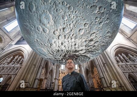 Der Resident Vicar, James Heard, steht mit der Installation des Museum of the Moon des Künstlers Luke Jerram in der St. John the Baptist Kirche im Westen Londons, Großbritannien. Stockfoto