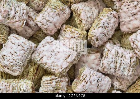 Zerfetzte Weizenkekse Frühstückszerealien mit Erdbeeraroma ohne Milch, Nahaufnahme direkt darüber. Stockfoto